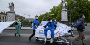 Protestierende mit einem Krankenhausbett.