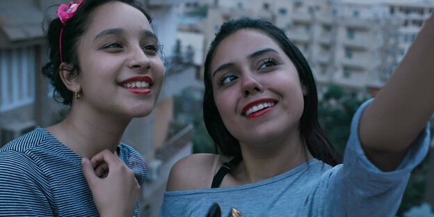 Zwei junge Frauen posieren im Freien für ein Selfie.