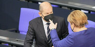 Scholz und Merkel reden miteinander im Bundestag.