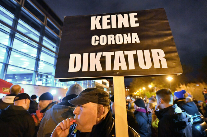 "Keine Corona Diktatur" steht auf einem schwarzen Protestplakat