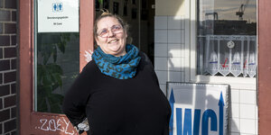 Helga Halbeck steht für ein Porträt für ihrer Arbeitsstätte in der Sonne und lacht, sie arbeitet als Toilettenfrau am Hamburger Fischmarkt