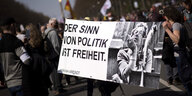 Demonstrierende gegen die Corona-Maßnahmen in Berlin halten ein Transparent mit Hannah Arendt auf dem steht: "Der Sinn von Politik ist Freiheit."