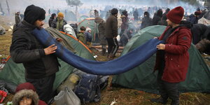 Menschen vor Zelten, im Hintergrund Wald