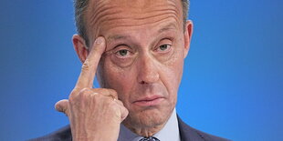 Friedrich Merz fasst sich an die Stirne.