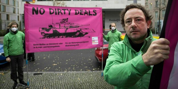 Greenpeace-Aktivisten halten ein Transparent auf dem ein Panzer mit der Forderung "No Dirty Deals" abgebildet ist