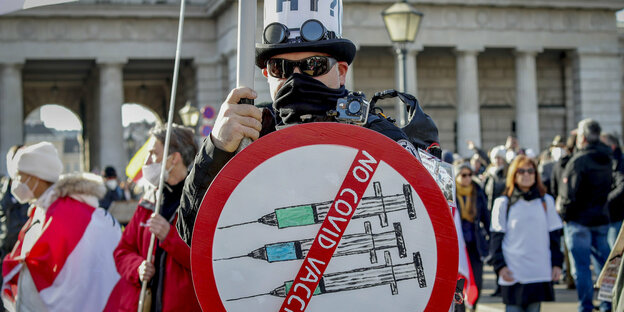 Ein Mann hält ein Schild gegen die Coronaimpfung hoch, während er an einer Demonstration gegen die Coronavirus-Beschränkungen des Landes teilnimmt.