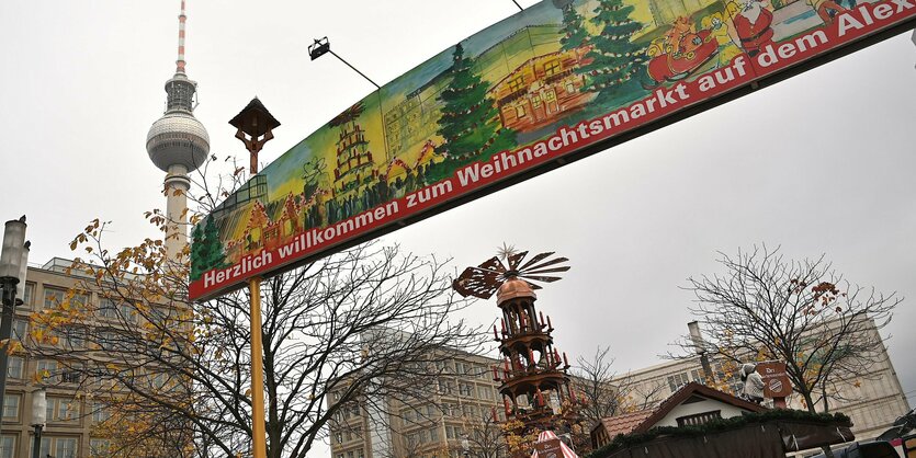 Ein Schild weist auf den Weihnachtsmarkt hin, im Hintergrund der Fernsehturm