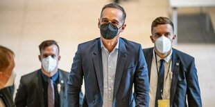 Heiko Maas mit schwarzer Maske und Anzug auf dem Weg zur ersten Fraktionssitzung der SPD nach der Bundestagswahl. Hinter ihm laufen ebenfalls Menschen mit Anzug und Maske