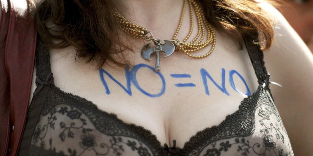 Eine Frau hat „No = No“ auf ihren Oberkörper geschrieben