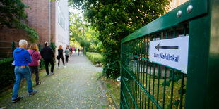 Menschen stehen Schlange vor einem Wahllokal