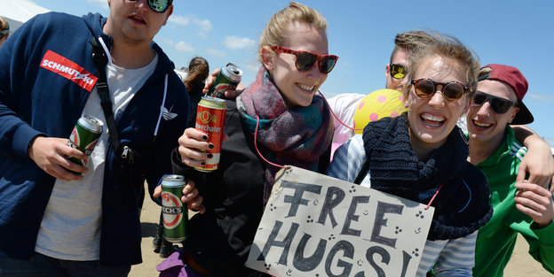 Freundesclique mit Schild "Free Hugs"