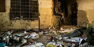 Ein Soldat steht in einem völlig verwüsteten Klassenzimmer, auf dem Boden liegen die Überreste der Einrichtung