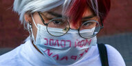 Mensch mit OP-Maske auf der Steht: „Meine Stimme wurde mir gestohlen“