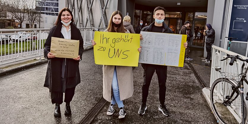 Schülerinnen und Schüler zeigen Plakate, die ihre Solidarität ausdrücken.