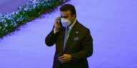 Ahmed al-Raisi spricht in ein Telefon und trägt eine weiße Gesichtsmaske