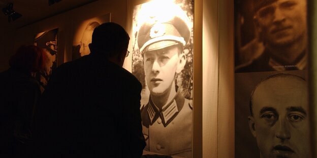 Ein Besucher vor dem Portrait eines Wehrmachztssoldaten in der Ausstellung über die Verbrechen der Wehrmacht