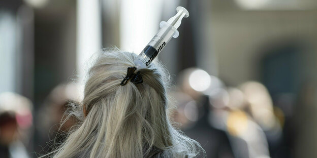 Eine Impfgegnerin hat sich eine Spritze in die grauen Haare gesteckt