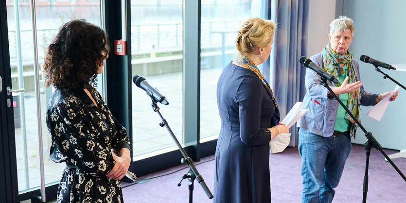 Drei Frauen stehen auf einer Pressekonferenz