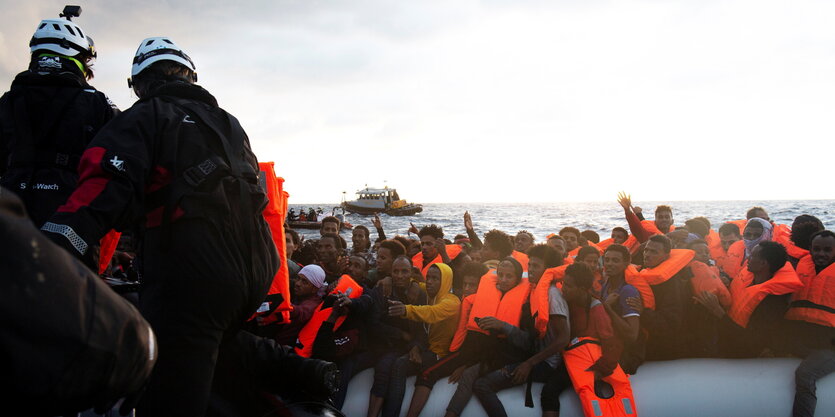 Gerettete winken aus einem Gummiboot