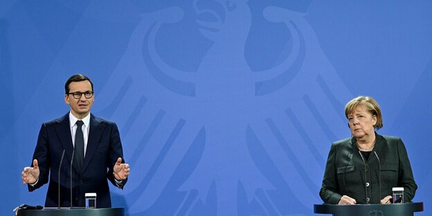 Merkel und Morawiecki stehen am Rednerpult