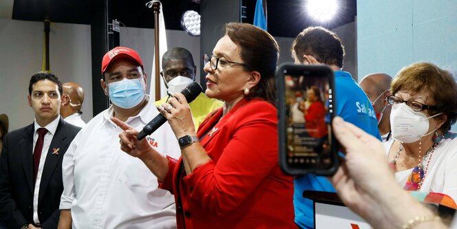 Xiomara Castro bei einer Pressekonferenz umgeben von Menschen.