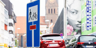 Ein Einbahnstraßenschild steht auf der Schmiedestraße, im Hintergrund sind Geschäfte und die Marktkirche erkennbar.