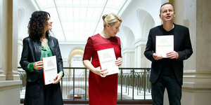 Bettina Jarasch, Franziska Giffey und Klaus Lederer halten je ein Exemplar des Koalitionsvertrags in den Händen