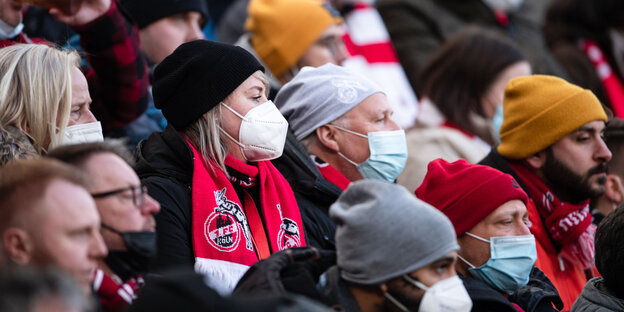 Kölner Fußballfans stehen dicht gedrängt, einer von ihnen ohne Maske.