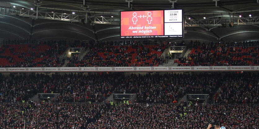 Ein Videodisplay weist auf das Abstand halten im Stuttgarter Stadion hin.