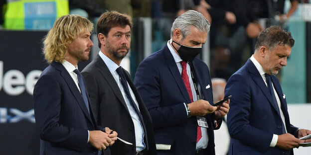 Vier Juve-Funktionäre in Anzügen am Spielfeldrand