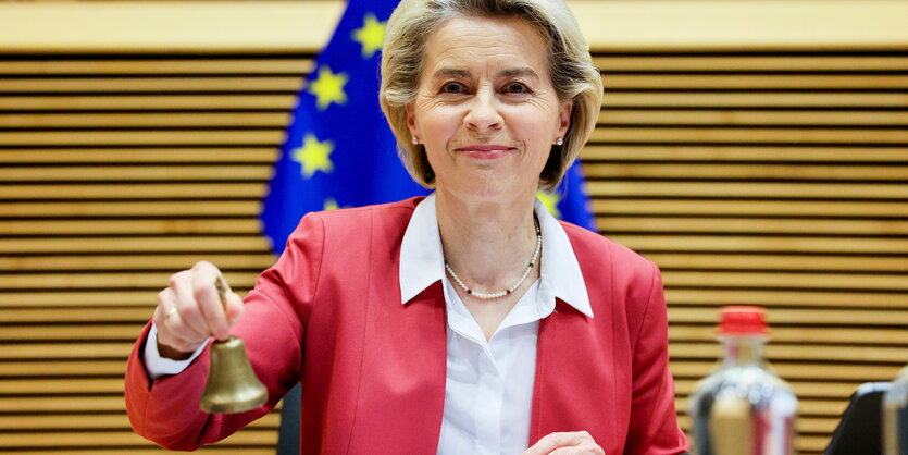 Ursula von der Leyen mit einer Glocke.