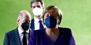 Angela Merkel und Olaf Scholz und ein weiterer Mann mit Mundschutzmasken