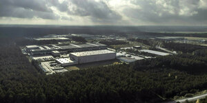 Neu gebaute Fabrikhallen stehen in einem Wald