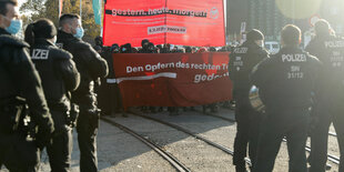 Demonstration mit Transparent, im Vordergrund Polizei.