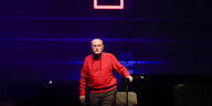Der Komponist Alvin Lucier in rotem Pullover auf der Bühne