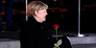 Angela Merkel mit einer Rose in der Hand.