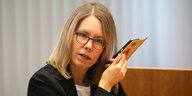Oberstaatsanwältin Anne Brorhilker hält ein Smartphone an ihr Ohr