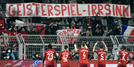 Profis des FC Bayern München stehen vor der Tribüne und klatschen Fans zu