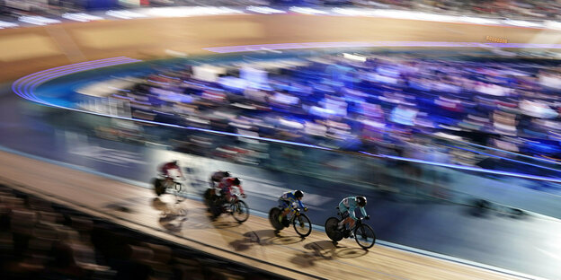 Ein volles Velodrom in London, im vorderen BEreich sieht man vier Radsportlerinnen im Sprint