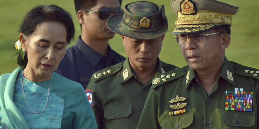 Eine Dame (Aung San Suu Kyi) neben zwei Militärs, von denen einer später den Putsch gegen sie führte.