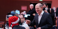 Olaf Scholz (SPD), designierter Bundeskanzler, begrüßt ein Parteimitglied mit Weihnachtsmannmütze beim Berliner SPD-Landesparteitag.