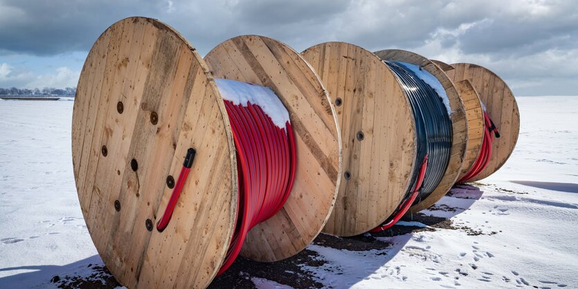 Bunte Glasfaserkabel auf Rollen in einer Winterlandschaft