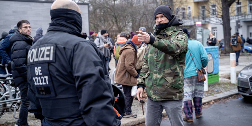 Ein Mann und Polizist stehen sich auf einer Straße konfrontativ gegenüber