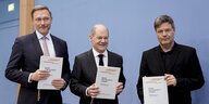 Christian Lindner, Olaf Scholz und Robert Habeck halten je eine Ausgabe des Koalitionsvertrags in den Hönden