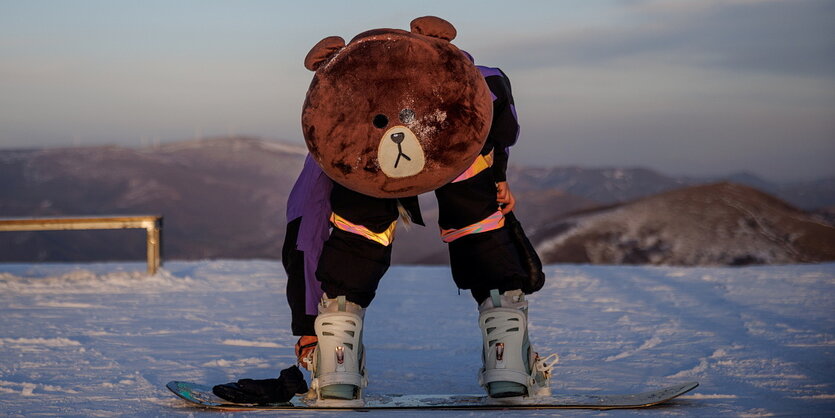 Ein Snowboarder trägt ein Kuscheltierkostüm