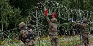 Soldaten erstellen einen Zaun aus Stacheldraht