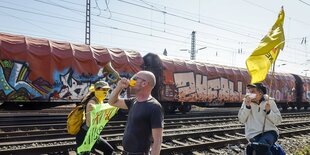 Menschen mit Fahnen an einem Güterbahnhof