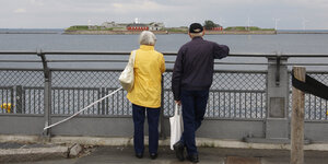Ein altes Paar schaut auf eine Insel im meer