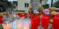 Blumen und Kerzen stehen vor dem Wohnhaus in Senzig, in dem der Vater sich und seine Familie tötete