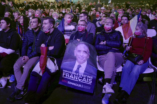 Im sitzenden Publikum von Zemmour sitzen vor allem Männer, einer hält ein Plakat mi dem Konterfei des Kandidaten